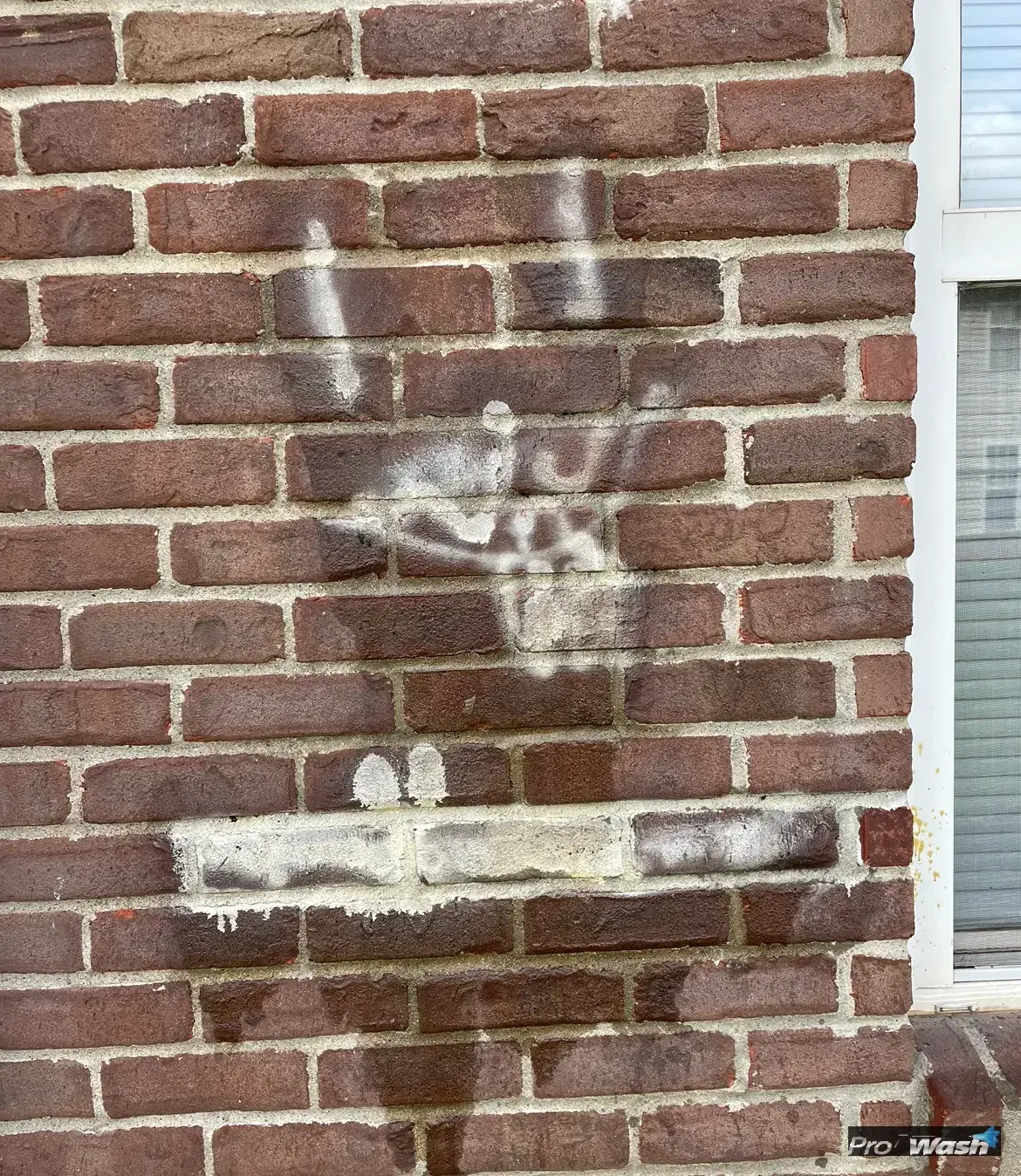 Spray paint graffiti being removed from a brick wall in Lexington, KY.