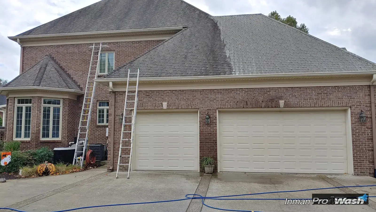 A central Kentucky brick home with ladders set for a soft wash roof cleaning by Inman ProWash.
