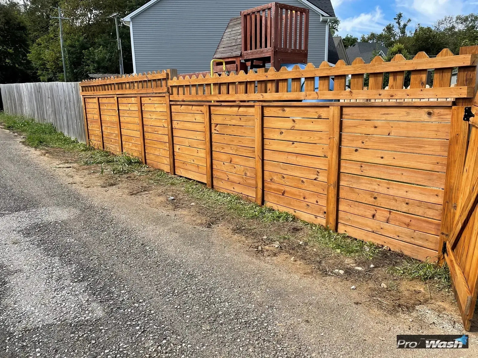 A restored cedar privacy fence after a soft wash and re-stain by Inman ProWash.