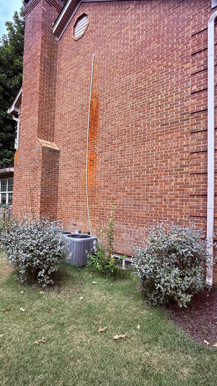 Brick wall on a Lexington home with a heavy rust stain running top to bottom before rust treatment