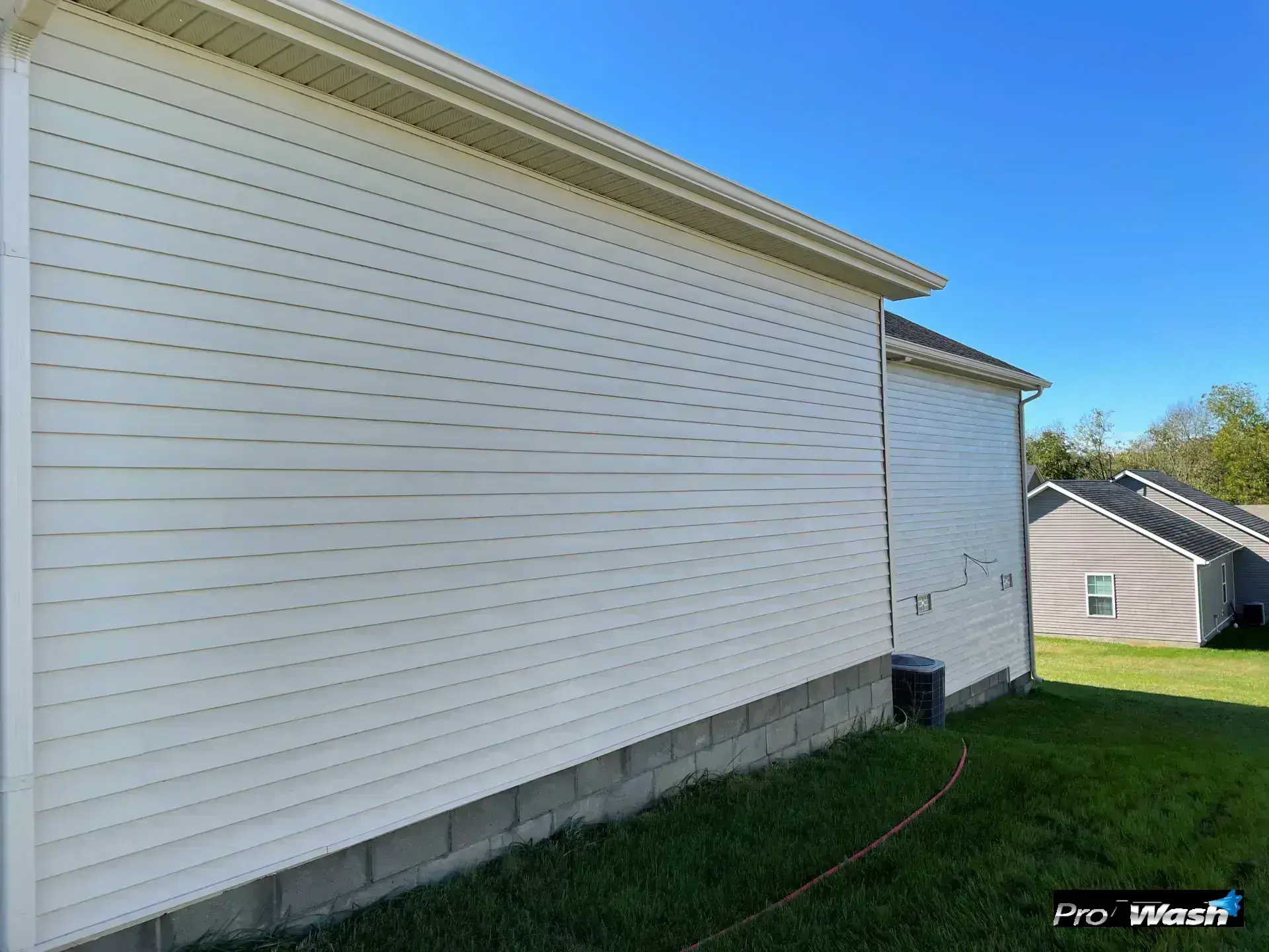 The same home's exterior siding looking clean, bright, and free of algae and mold after professional soft washing.