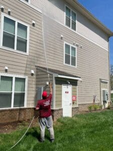 Rinsing upper floors of apartment complex with extended wand