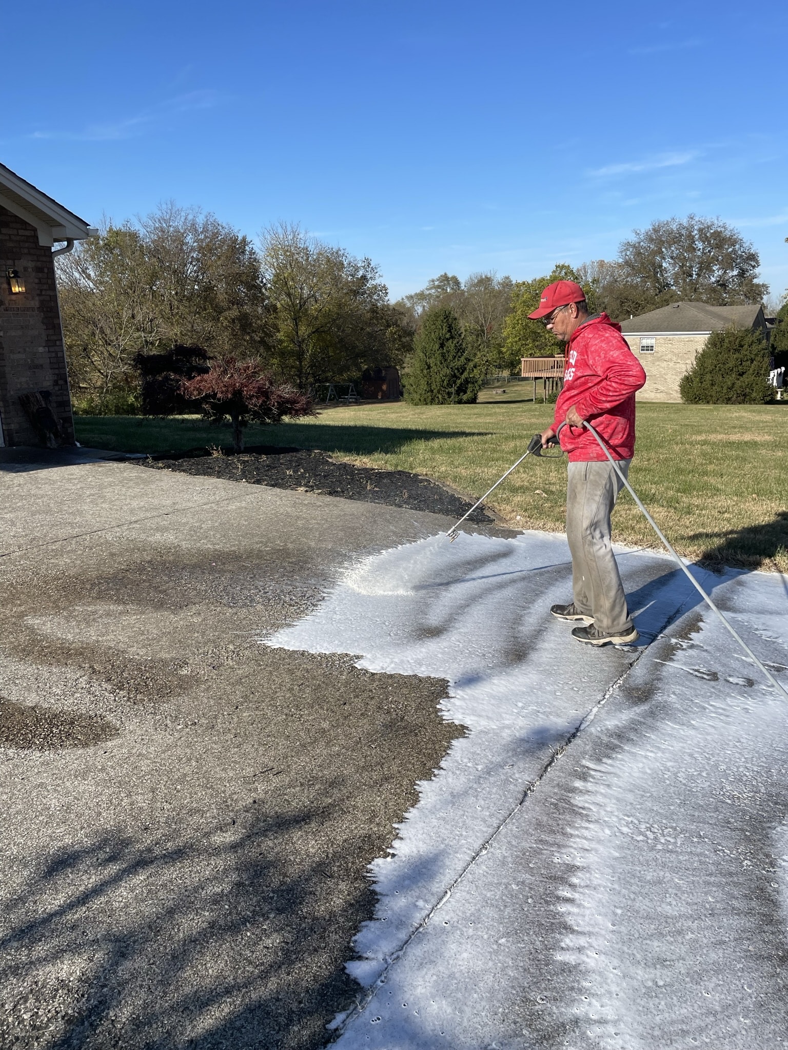 Spraying detergent on driveway